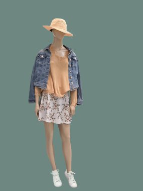 Modaya uygun giyinmiş, yeşil arka planda izole edilmiş tam boy kadın mankeni. Marka isimleri veya telif hakkı nesneleri yok.