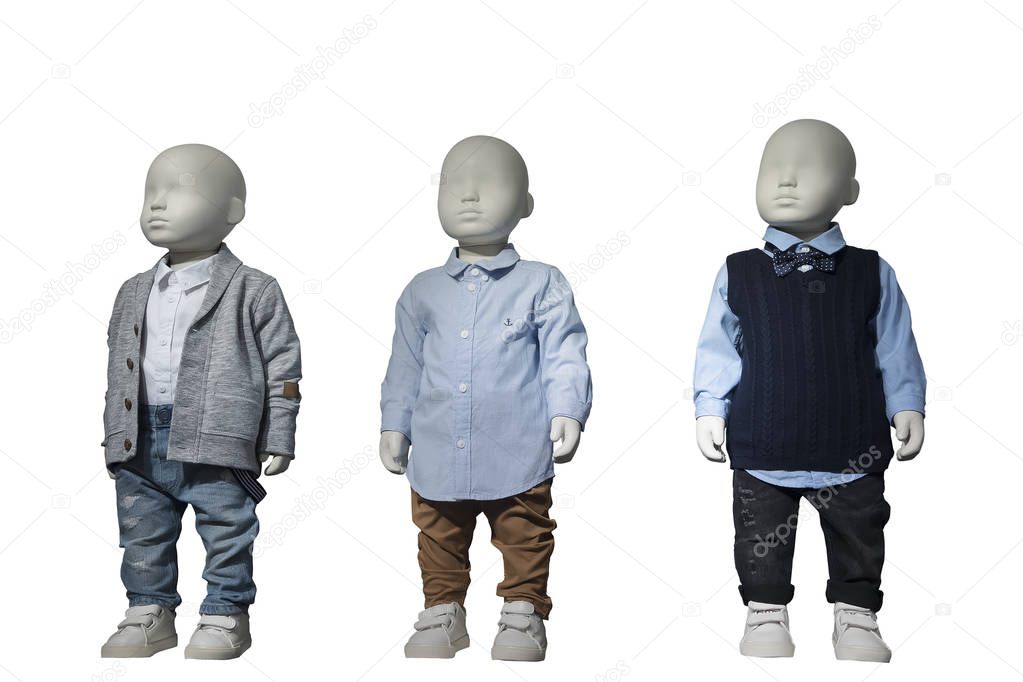 Three mannequins dressed in kids wear.