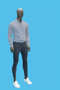 Modaya uygun giyinmiş, mavi arka planda izole edilmiş uzun boylu erkek manken. Marka isimleri veya telif hakkı nesneleri yok.