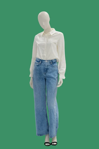 緑の背景に隔離された白いブラウスと青いジーンズに身を包んだ完全な長さの女性のマネキン ブランド名や著作権の対象外 — ストック写真