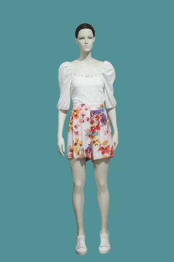 Yeşil arka planda izole edilmiş, yaz modasına uygun giyinmiş uzun boylu kadın mankenler. Marka isimleri veya telif hakkı nesneleri yok.