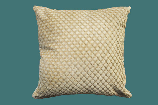 Beige decorative pillow. Isolated on green background.