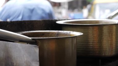Indian-style Coffee Pot Stirring in Busy Cafe