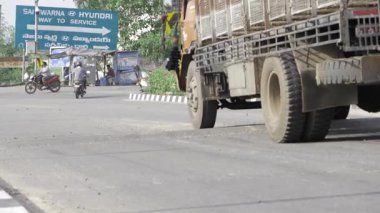 Truck Navigating Road with Sign and Bushes