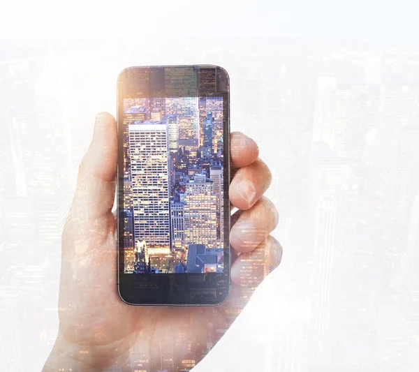 Hand taking picture of city with smart phone. Photography and art concept. Double exposure