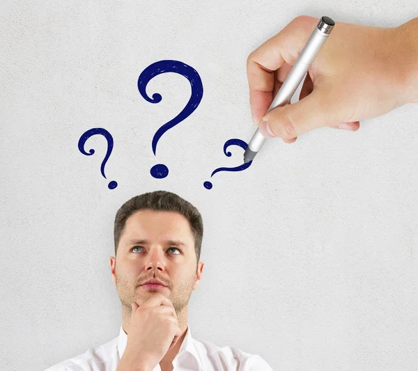 Thoughtful Businessman Drawn Question Marks Standing Concrete Wall Background Confusion — Stock Photo, Image