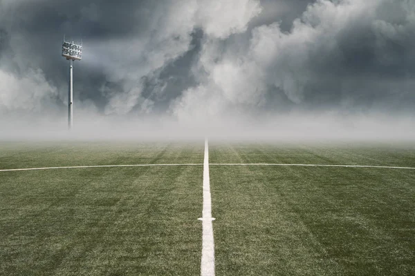empty football field with white line in the middle, projector and blue cloudy sky. 3D render