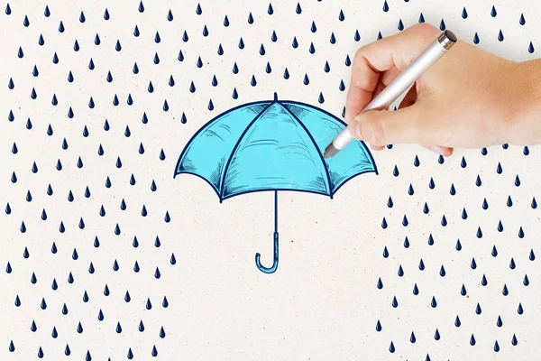 concept of protection and security wall with hand and pencil drawing rain and blue umbrella.