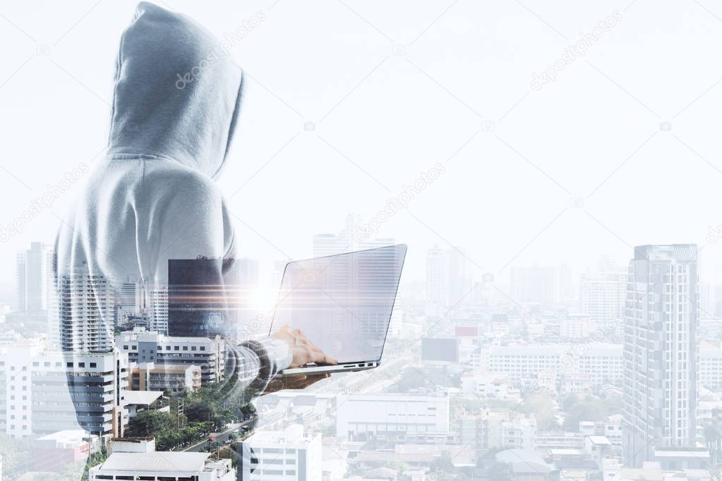 double exposure with hacker in hoody with laptop and megapolis view background. 3D render