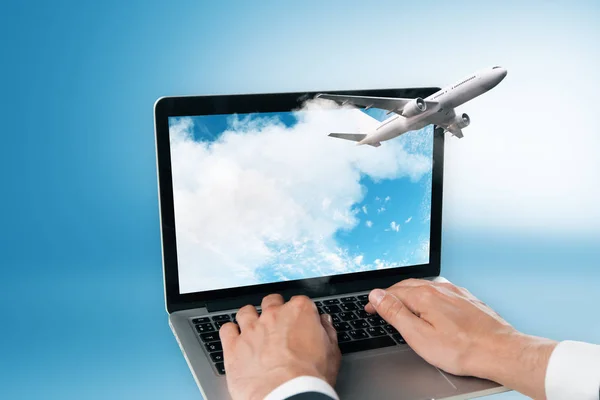 take off plane from laptop monitor and man hands at blue background