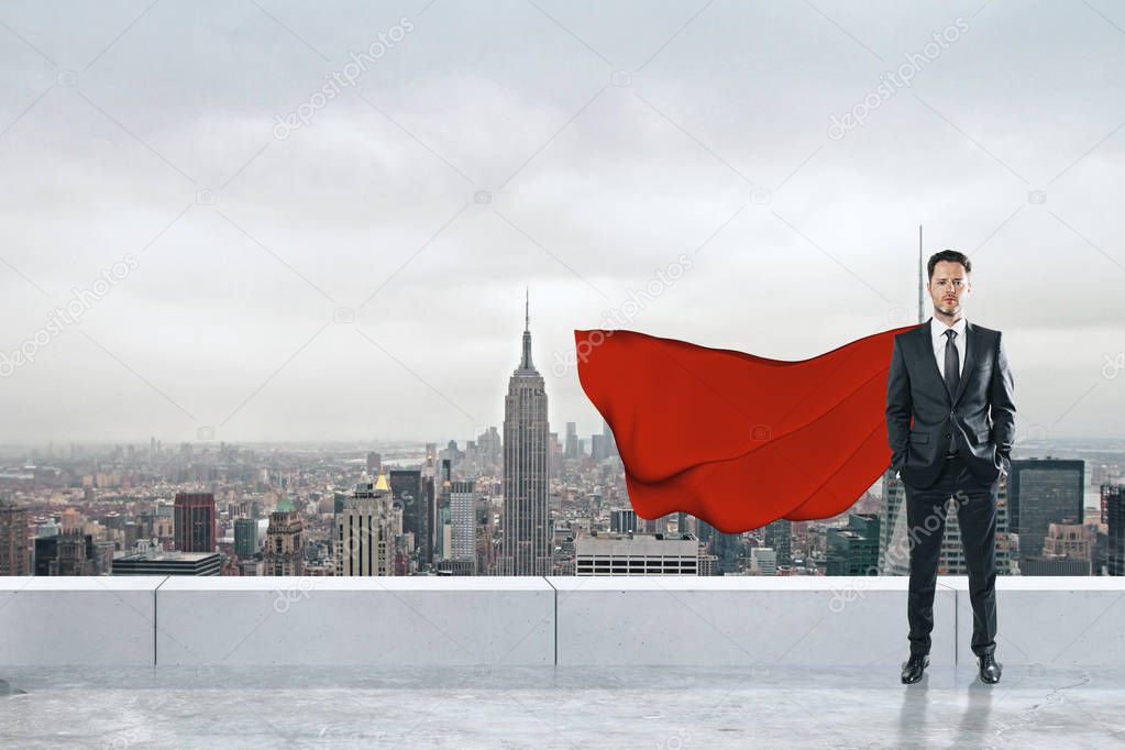 Businessman with red hero cape standing on rooftop with city background. Leadership and confidence concept 