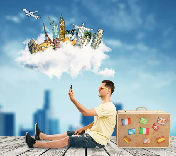年轻男子与手提箱采取自拍与智能手机在抽象的天空背景和创造性的旅行素描 旅游理念 — 图库照片