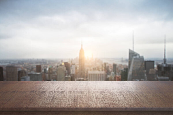 Empty wooden desk on blurry city background. Mock up
