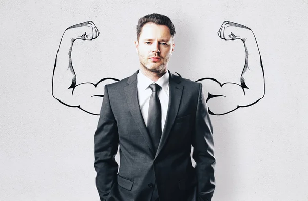 Portrait of attractive young businessman with drawn muscly arms. Confidence and power concept