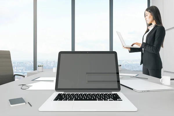 有吸引力的年轻的欧洲女实业家使用空笔记本电脑在现代办公室内饰与城市景观和日光 快关门模拟 — 图库照片