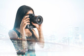 Mladé samice focením s profesionální kamerou na pozadí abstraktní města. Dvojitá expozice 