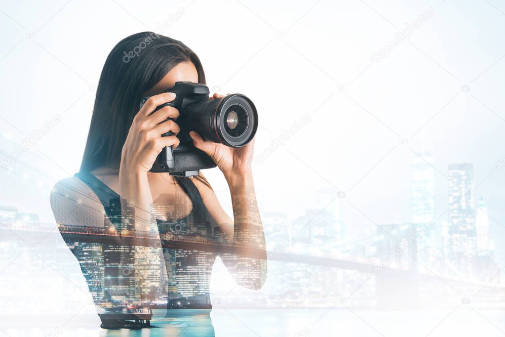 Young female taking picture with professional camera on abstract city background. Double exposure 