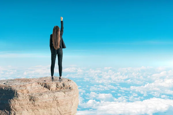 自信的年轻女实业家站在天空背景的举起胳膊 成功与挑战理念 — 图库照片