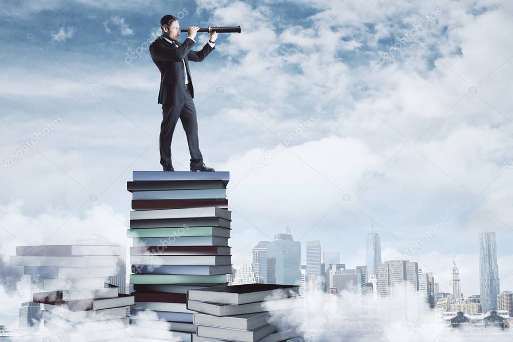 Curios businessman standing on book pile on cloudy sky and city background. Research and education concept 