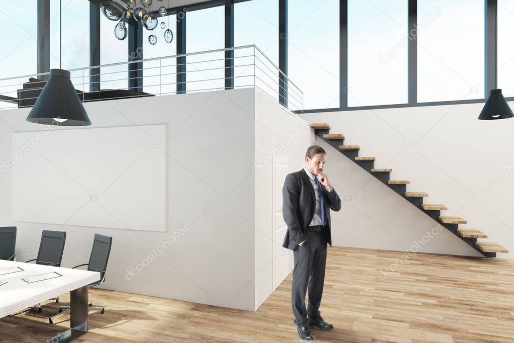 Thinking businessman standing in modern office interior with panoramic sky view.