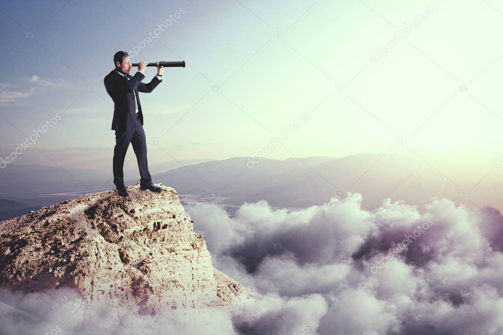 Side view of young businessman using telescope on cliff. Vision and challenge concept 