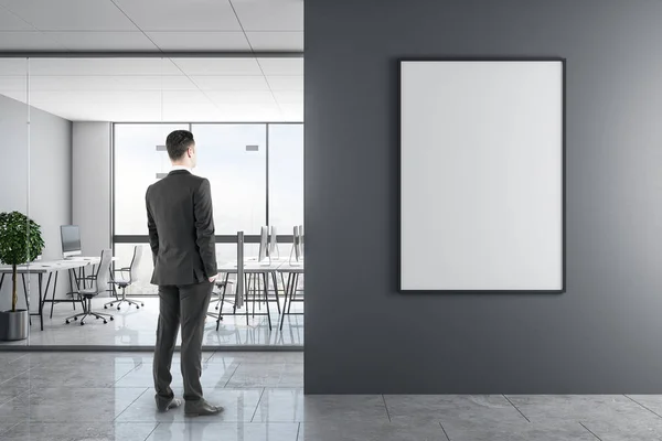 Junger Geschäftsmann Modernen Bürointerieur Mit Leerem Poster Der Wand Attrappe — Stockfoto