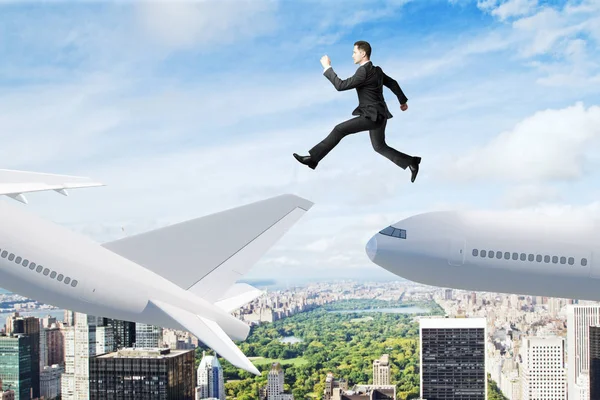 Businessman jumping on airplane on city background. Business travel and change concept.