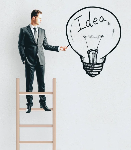 Young Businessman Standing Ladder While Drawing Idea Lamp Concrete Wall — Stock Photo, Image