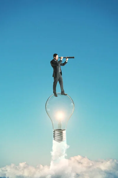 Young Businessman Looking Distance While Standing Launching Lightbulb Sky Background — Stock Photo, Image