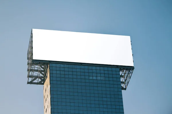 Pusty Biały Billboard Oszklonym Budynku Tle Błękitnego Nieba Ogłoszenie Komercyjnych — Zdjęcie stockowe