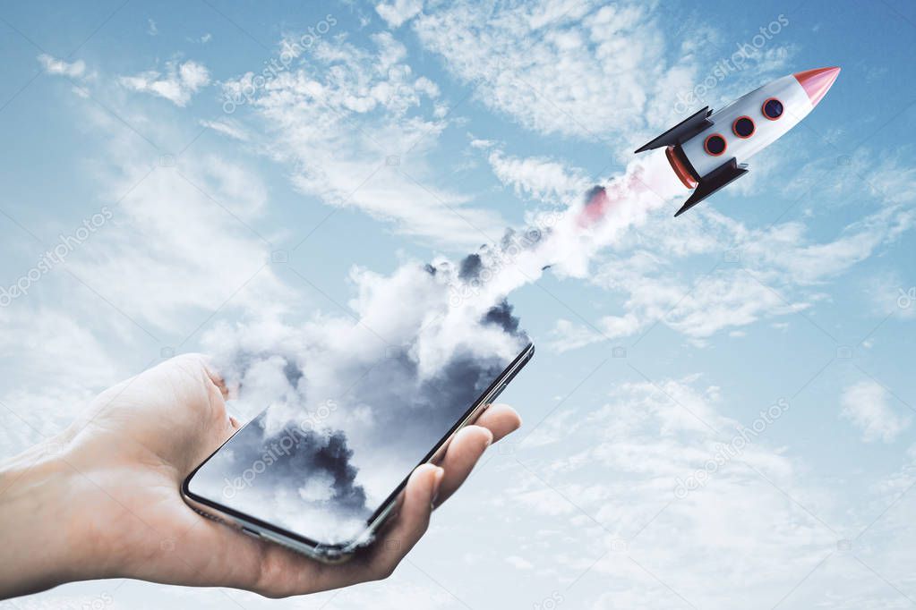 Hand holding smartphone with launching rocket on sky background. Startup and web concept