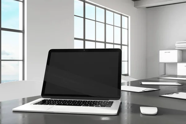 Designer desktop with empty black laptop computer screen in modern office interior. Design and ad concept. Mock up, 3D Rendering