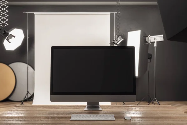 Close up of modern designer desktop with empty computer screen in modern studio interior. Mock up, 3D Rendering