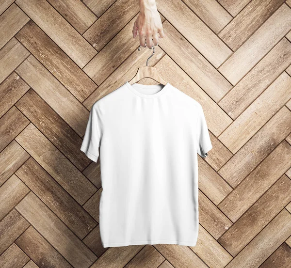 Ręka Gospodarstwa Wieszak Pusty Biały Shirt Tle Ściany Drewniane Deski — Zdjęcie stockowe