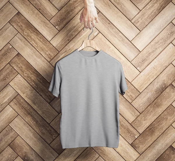 Appendino Mano Con Shirt Grigia Vuota Fondo Legno Concetto Design — Foto Stock