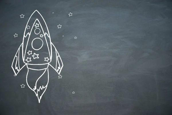 Creative rocket sketch on chalkboard wall background. Startup and entrepreneurship concept