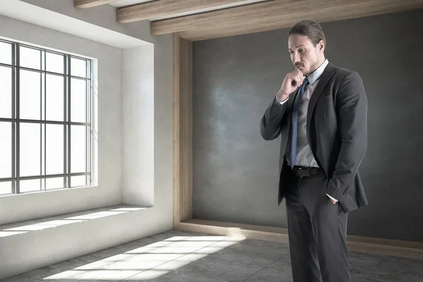 Businessman standing in concrete interior — Stock Photo, Image