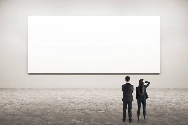 Empresarios mirando afiche — Foto de Stock