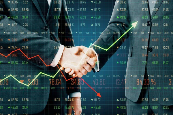 Business deal concept with man handshaking and business chart screen.