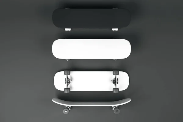 Tři prázdné bílé a jeden černý skateboardy na tmavě šedém pozadí. — Stock fotografie