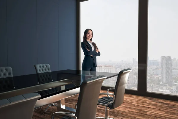 Femme d'affaires dans la salle de conférence moderne avec murs noirs et sol en bois sur fond de vue sur la ville . — Photo