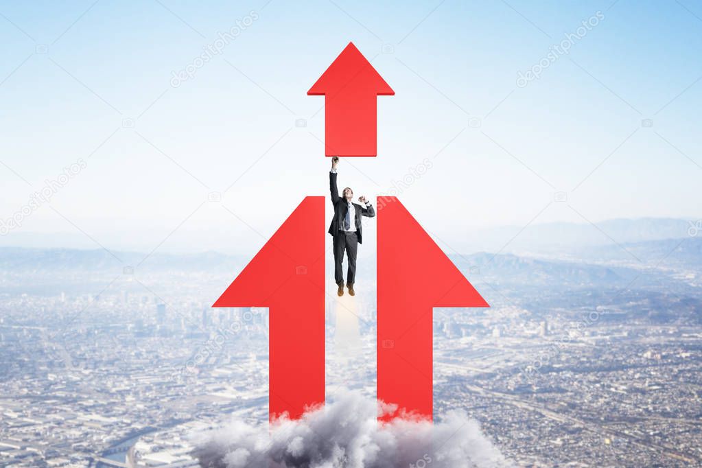 Ambition and goal concept with businessman taking off in the direction of red arrow.