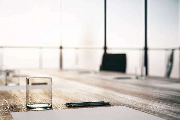 Primo piano del tavolo da conferenza in legno con vetro, penne e lastra bianca nel moderno ufficio del mattino . — Foto Stock