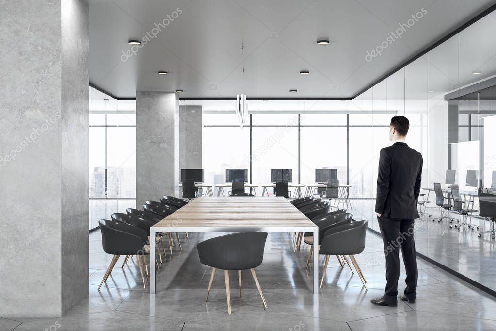 Businessman in luxury concrete office interior 