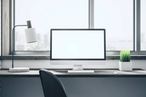Contemporary desktop with empty white computer screen, lamp on table and panoramic city view. Workplace and lifestyle concept. Mock up, 3D Rendering