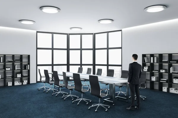 Businessman standing in coworking meeting room interior with city view and daylight. Business and corporate concept.