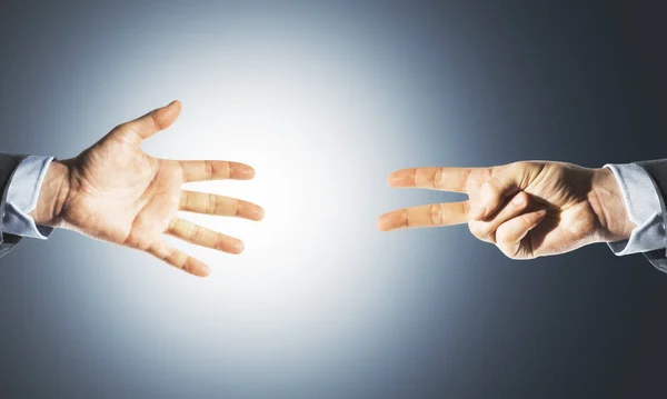 Two hands victory sign and palm on gray background. Business and challenge concept.