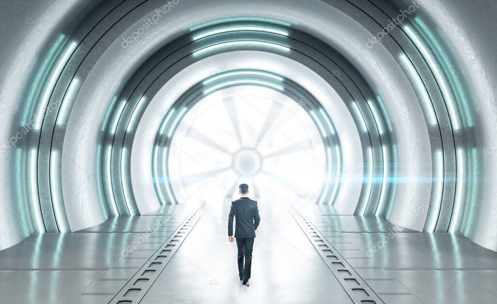 Businessman walking in futuristic concrete space ship interior with light. Abstract tunnel.  Future and design concept.