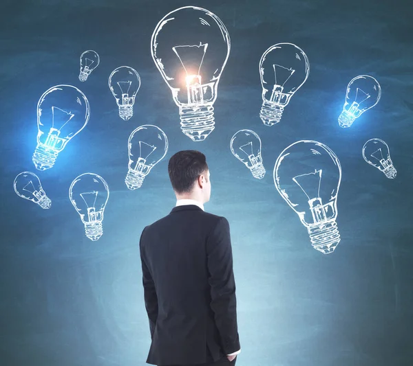青い背景にランプのスケッチと若いヨーロッパのビジネスマン アイデアと革新の概念 — ストック写真