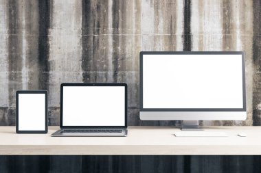 Dijital tablet, bilgisayar monitörü ve ofis masasında beton duvarda boş ekran olan dizüstü bilgisayar. Teknoloji ve iletişim konsepti. Modifiye et, 3B Hazırlama
